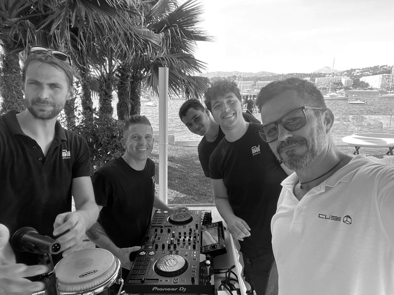 Group of DJs with equipment outdoors.